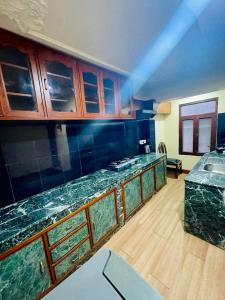 a kitchen with green marble counter tops and wooden cabinets at Hotel Bodhiz in Kathmandu