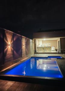 a swimming pool at night with blue lighting at Casa piscina 3 quartos in Goiânia