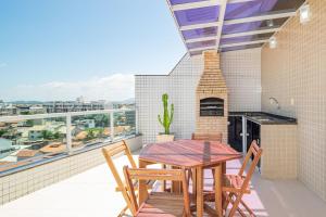 un patio con tavolo e sedie su un balcone di Cf02 Cobertura 3 quartos 200m da Praia das Dunas a Cabo Frio