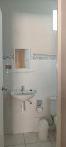a white bathroom with a sink and a toilet at HospedajesPerú in Zorritos