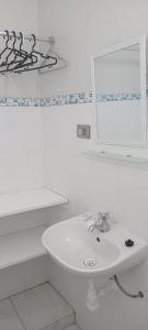 a white bathroom with a sink and a mirror at HospedajesPerú in Zorritos