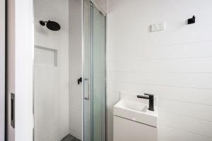 a bathroom with a sink and a glass shower at Bright Cabin Park in Bright +37 photos