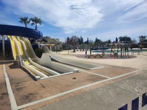 um parque infantil com escorrega num parque em camping sable du midi 4 etoiles em Valras-Plage