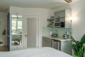 a bedroom with a bed and a kitchen with a microwave at Walkable to Beach, Restaurants & Shops. Remodeled! in Wailea