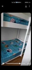 ein weißes Etagenbett mit einer blauen Bettdecke darauf in der Unterkunft Modern 2BR Condo with Fiber Net and Netflix in Davao City