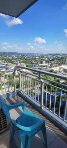 a balcony with a blue bench and a view of a city at Modern 2BR Condo with Fiber Net in Davao City