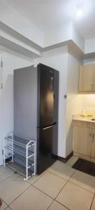 a kitchen with a black refrigerator in a room at Modern 2BR Condo with Fiber Net in Davao City