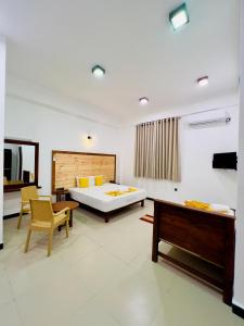 een slaapkamer met een bed, een bureau en een bank bij The Golden Park Hotel in Anuradhapura