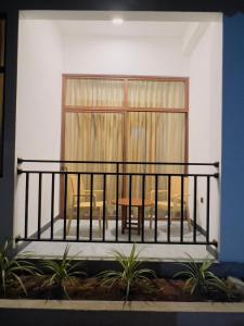 een balkon met een tafel en stoelen voor een raam bij The Golden Park Hotel in Anuradhapura
