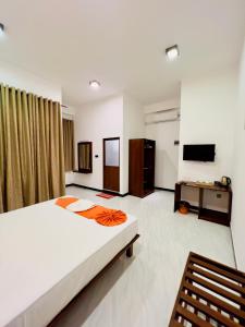 een slaapkamer met een groot bed en een televisie bij The Golden Park Hotel in Anuradhapura