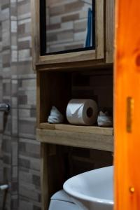 a bathroom with a toilet and a cabinet with a roll of toilet paper at Good Vibes Apartments in Talamanca