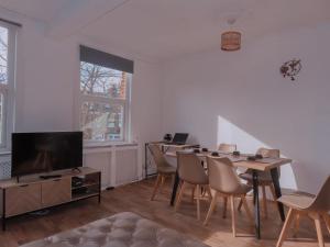 sala de estar con mesa, sillas y TV en Budget 2BDR apartment 6PPL pets en Teddington