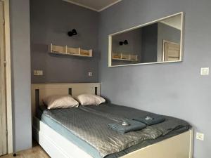 a small bedroom with a bed with a mirror at Apartament MRĄGOWIA in Mrągowo