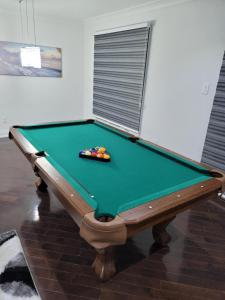 a pool table in a living room with afits at Beautiful Langston Home in Brampton