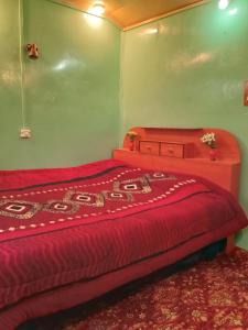 1 dormitorio con 1 cama con colcha roja en H.B Holiday home, en Srinagar