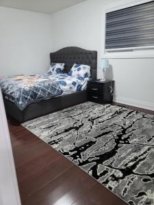 een slaapkamer met een bed en een tapijt bij Beautiful Langston Home in Brampton