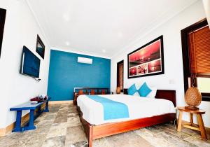 a bedroom with a large bed and a blue wall at Relax Garden Boutique Villa Hoi An in Hoi An