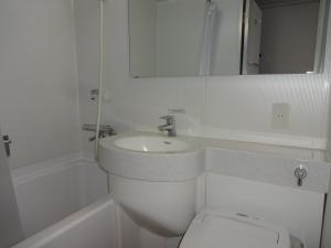 出雲市にあるホテルアルファーワン出雲の洗面台とトイレを備えた白いバスルーム