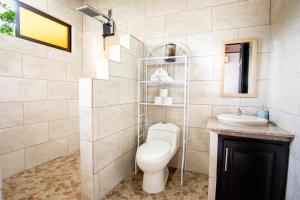 a bathroom with a toilet and a sink at Rio Celeste, Aire Acondicionado, Comodidad in Upala