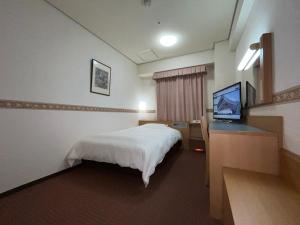 出雲市にあるホテルアルファーワン出雲のベッドと薄型テレビがあるホテルの部屋