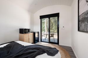 a bedroom with a bed and a balcony with a table at Bright Cabin Park in Bright