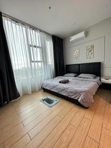 - une chambre avec un lit et une grande fenêtre dans l'établissement Manhattan Suites by NAJ, à Penampang