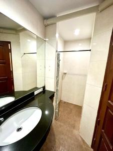 a bathroom with a sink and a shower at บ้านสวนรีสอร์ท นครสวรรค์ in Nakhon Sawan