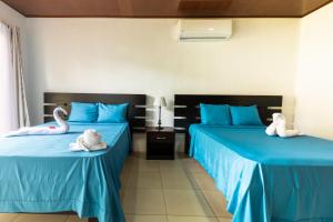 two beds in a room with swans on them at Rio Celeste, comodidad, Aire Acondicionado in Upala