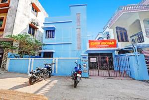 two motorcycles parked in front of a blue building at Hotel Madison Homes Bhubaneswar Near Lingaraj Temple and Ram Mandir in Bhubaneshwar