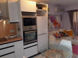 eine kleine Küche mit einem Glastisch vor einer Couch in der Unterkunft Sole e Mare 2 pièces aperçu mer in Golfe-Juan