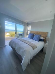 a bedroom with a large bed with a view of the ocean at 42 Whale Rock Estate in Hermanus