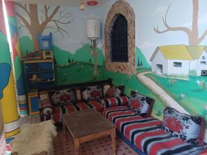 een woonkamer met een muurschildering aan de muur bij Atlase Surf hostel in Taghazout