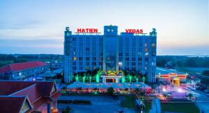 a hotel with a lit up sign on top of it at Ha Tien Vegas Entertainment and Resort in Kampot