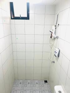 La salle de bains est pourvue d'une douche, de toilettes et d'une fenêtre. dans l'établissement Imperio Homestay Alor Star, à Alor Setar