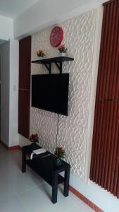 ein Wohnzimmer mit einem TV an der Wand in der Unterkunft SMDC Fame Marcelle's Place near Mega Mall in Manila