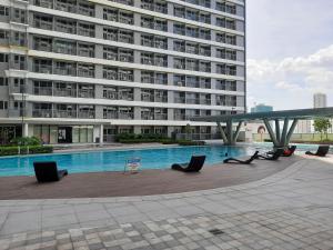 ein großes Gebäude mit einem Pool vor einem Gebäude in der Unterkunft SMDC Fame Marcelle's Place near Mega Mall in Manila