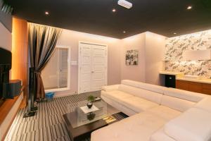 a living room with a white couch and a table at Tanjung Bungah 5BR 18 Bungalow KTV in Tanjung Bungah
