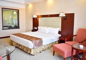 um quarto de hotel com uma cama e uma cadeira em Ha Tien Vegas Entertainment and Resort em Kampot