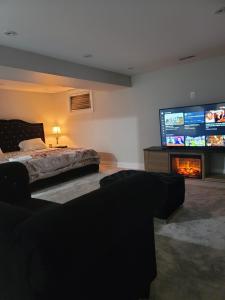 een slaapkamer met een bed, een tv en een open haard bij Beautiful Langston Home in Brampton