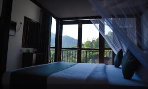 een slaapkamer met een bed en een groot raam bij Ever Breeze Ella Hotel in Ella