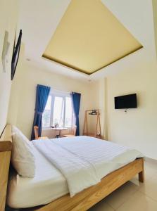 - une chambre avec un grand lit et une télévision dans l'établissement MIAN HOUSE, à Đà Lạt