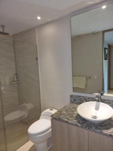 a bathroom with a sink and a toilet and a mirror at BONITO DEPARTAMENTO PENINSULA IXTAPA 02 Recámaras in Ixtapa