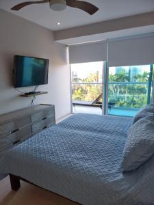 a bedroom with a bed and a flat screen tv at BONITO DEPARTAMENTO PENINSULA IXTAPA 02 Recámaras in Ixtapa