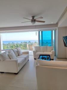 a living room with white couches and a large window at BONITO DEPARTAMENTO PENINSULA IXTAPA 02 Recámaras in Ixtapa