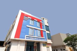 un edificio con una fachada de color rojo blanco y azul en OYO Flagship Hotel Kothiwal, en Muthiganj