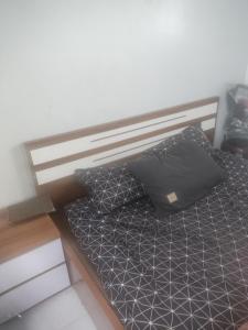 - un lit avec un oreiller noir dans l'établissement Nhà Nghỉ Minh Đức, à Kim Côn