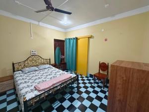 a bedroom with a bed and a checkered floor at Anjali HOMESTAY in Siliguri
