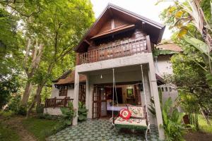 a house with a porch with a swing at Lanna Charm 5BR Villa in Maerim in Mae Rim