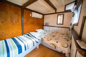 een kleine slaapkamer met een bed in een huis bij Haryugetu Guesthouse in NASA in Kaiyo