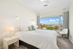 Port NoarlungaOcean View in Port Noarlunga的卧室里有一张白色的床和一扇大窗户